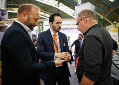 Un magicien présente un tour à deux visiteurs du stand de l'entreprise Giron sur le salon SIM 24